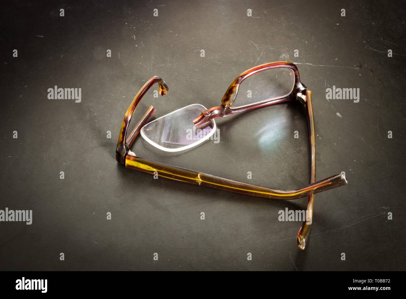 Broken eyeglasses on desk or ground Stock Photo