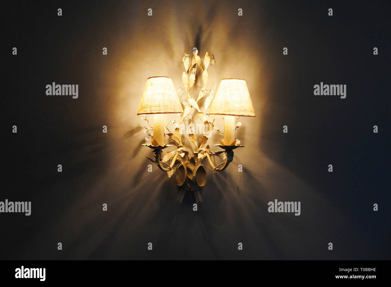 Decorative wall lights producing moody shadows - John Gollop Stock Photo