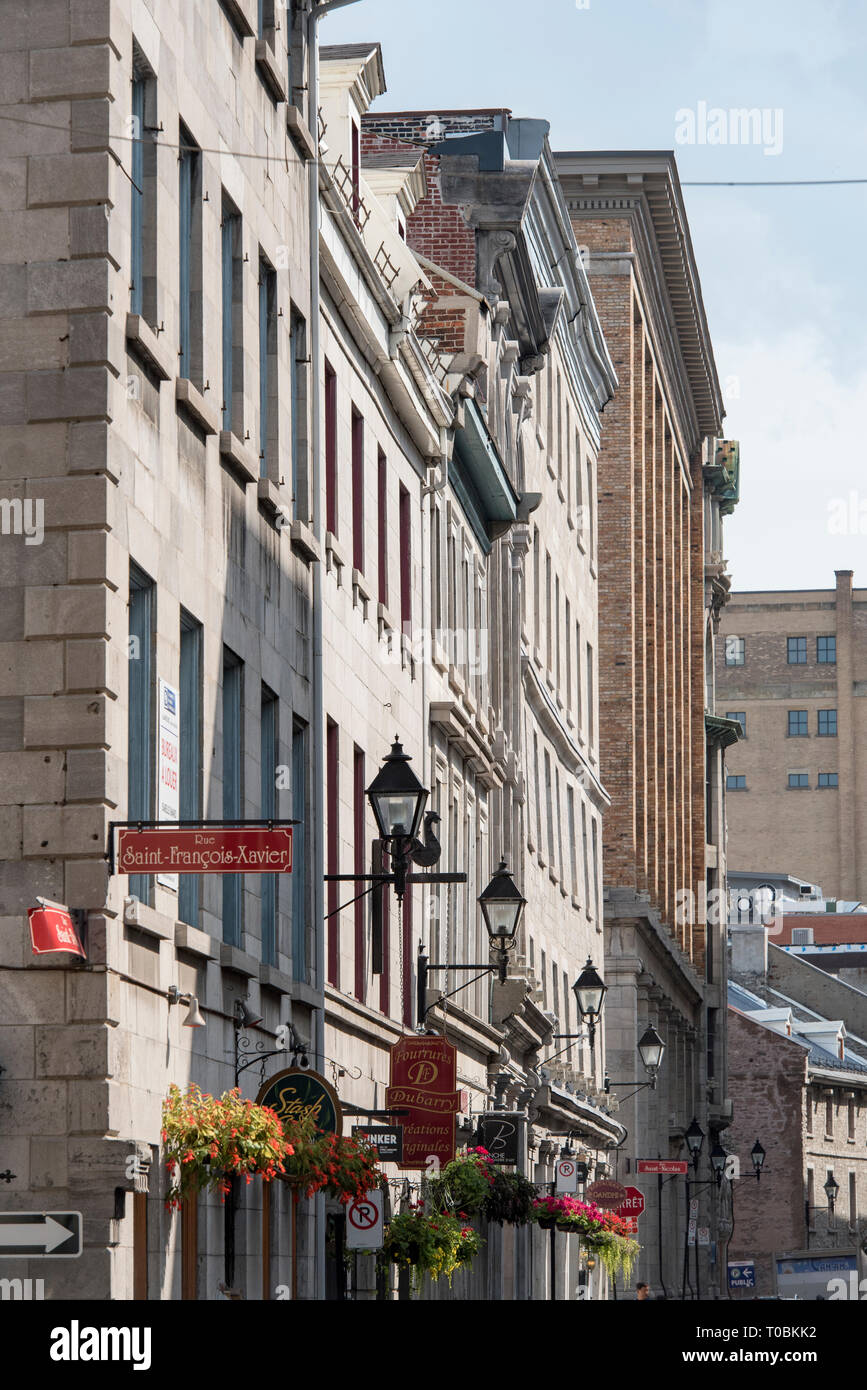 Montreal, Quebec, Canada. Hanging flower baskets and shop signs along