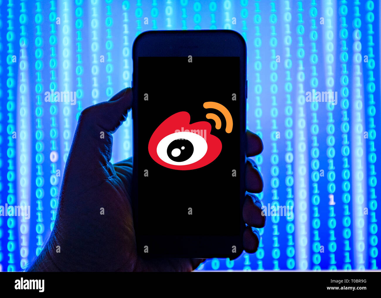Person holding smart phone with  Chinese Weibo  logo displayed on the screen. Sina Weibo is a Chinese microblogging website and one of the biggest soc Stock Photo