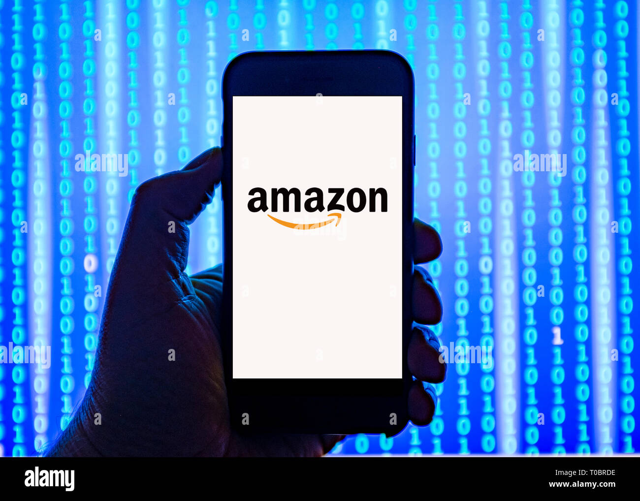 Person holding smart phone with  Amazon.com  logo displayed on the screen. Stock Photo