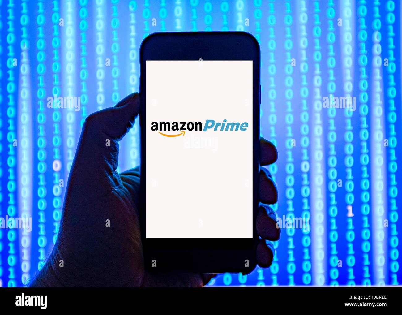 Person holding smart phone with Amazon Prime logo displayed on the screen. Stock Photo