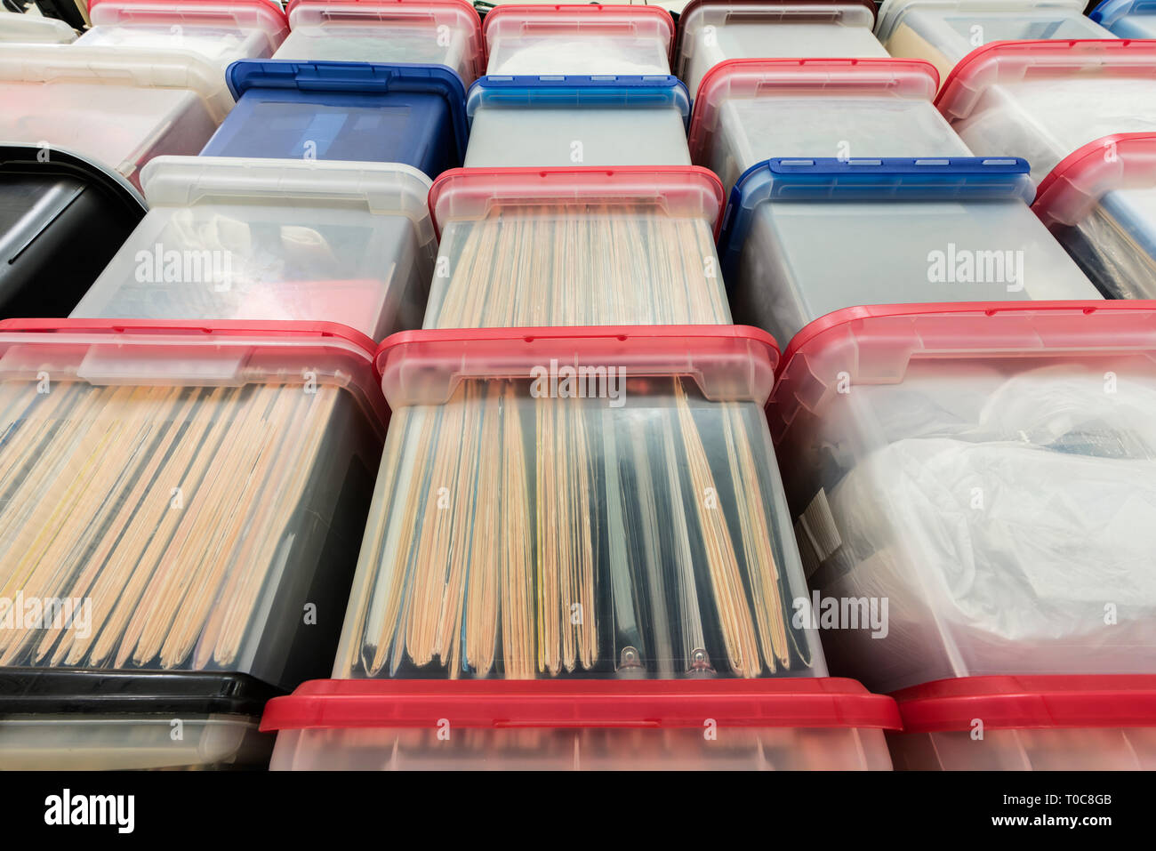 Tall wall of plastic file storage boxes with folders, binders and miscellaneous supplies. Stock Photo