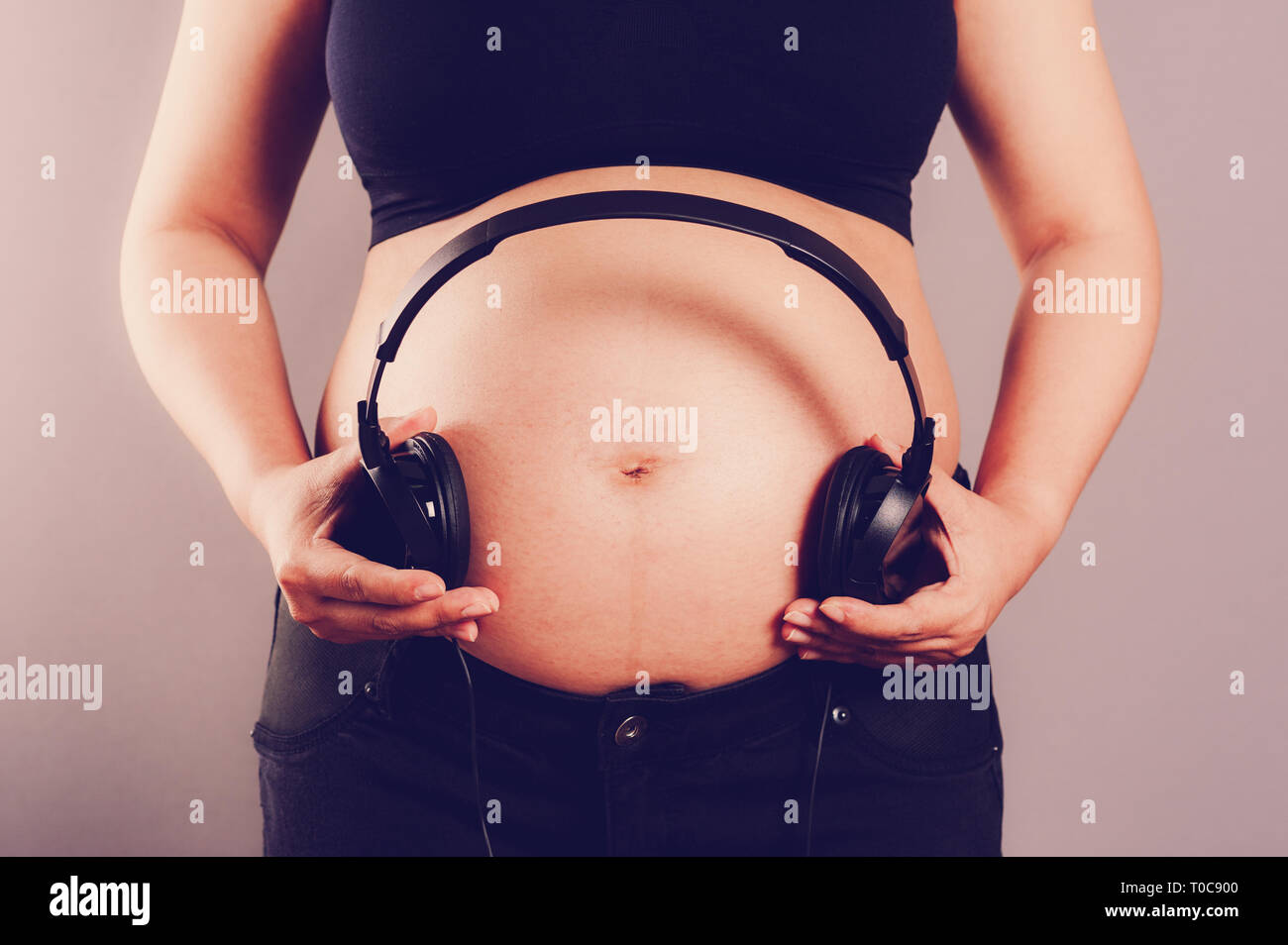 Pregnant woman with headphones close to her belly Stock Photo by  ©SIphotography 51627589