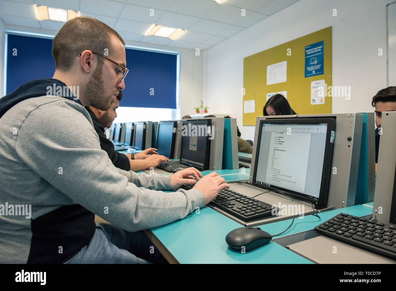 international students and pupils in the computer room of a college