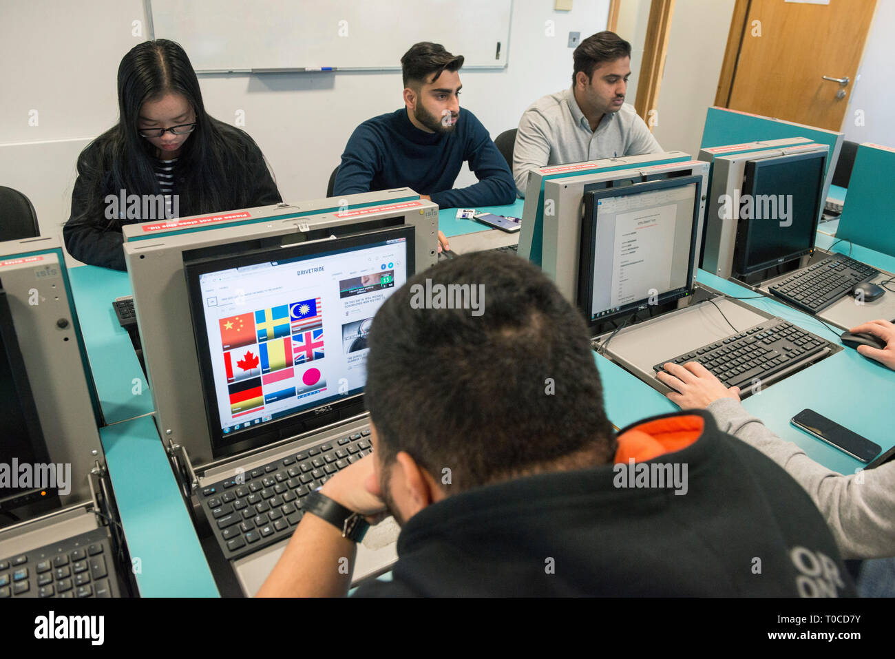 international students and pupils in the computer room of a college