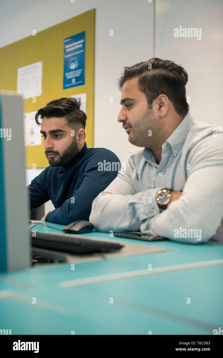 international students and pupils in the computer room of a college