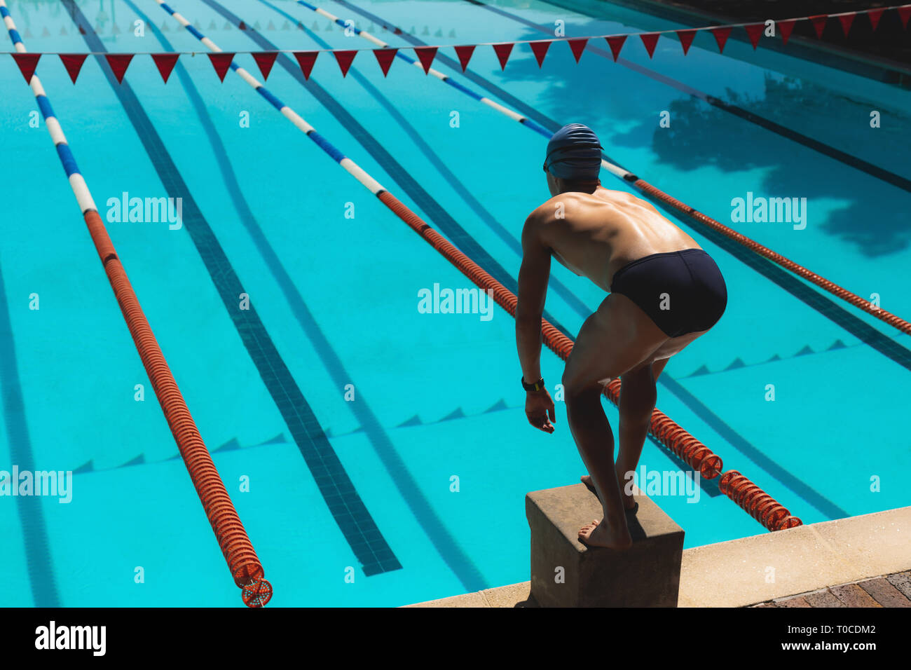 Young male swimmer standing on starting block Stock Photo