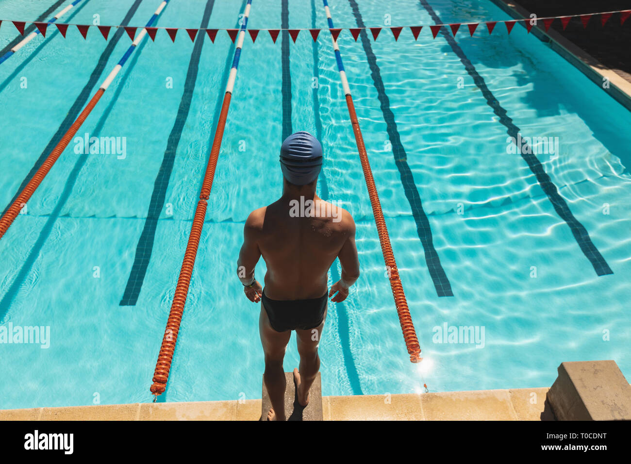 Young male swimmer standing on starting block at swimming pool Stock Photo Alamy