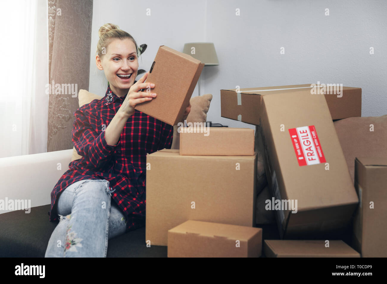 excited woman opening boxes after home delivery Stock Photo