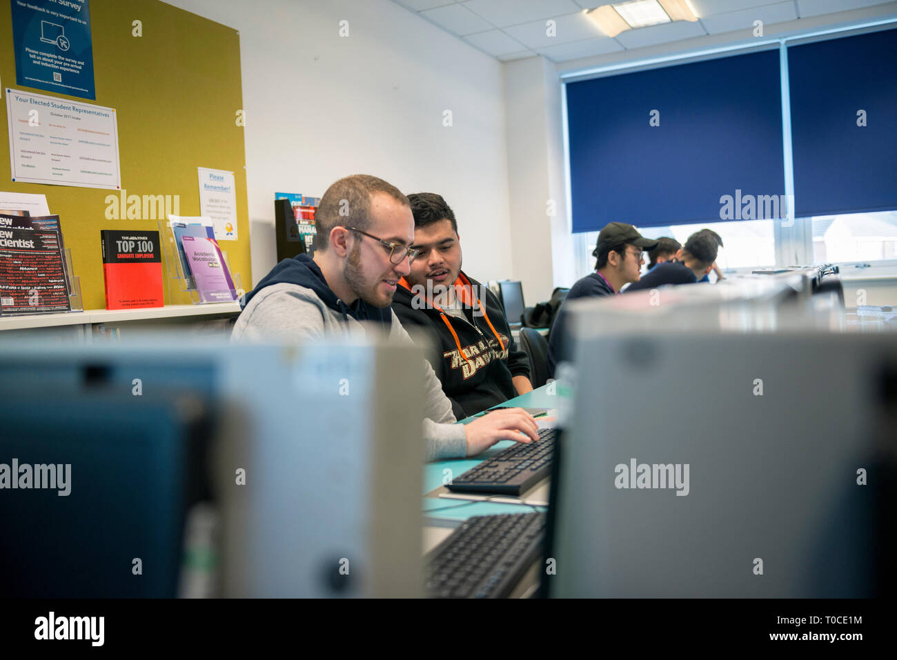 international students and pupils in the computer room of a college / university studying and using the desktop computers Stock Photo