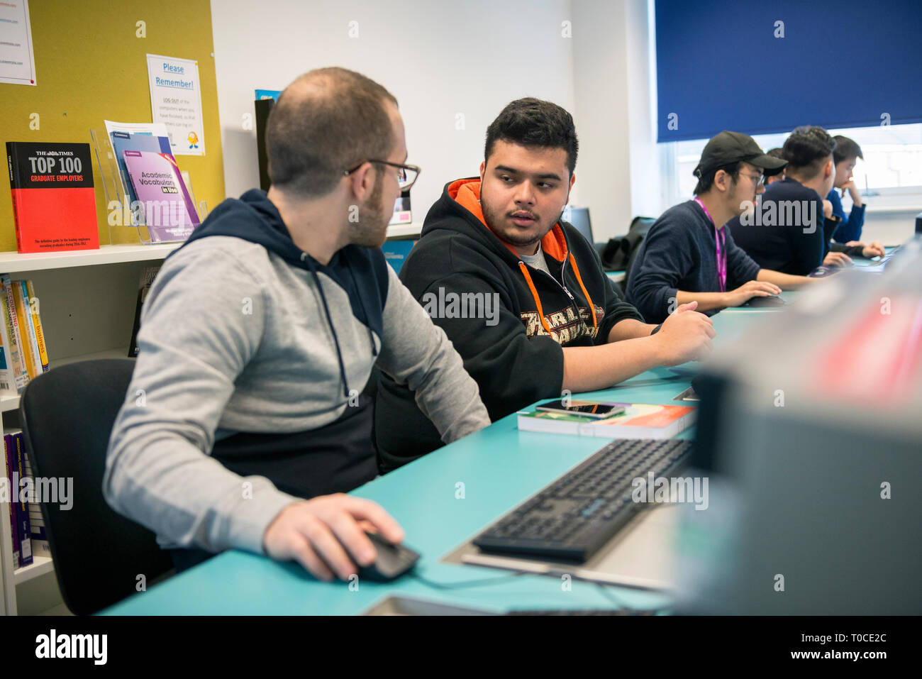 international students and pupils in the computer room of a college