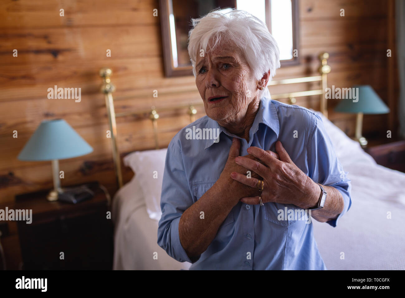 Active senior woman suffering from chest pain in bedroom at home Stock ...