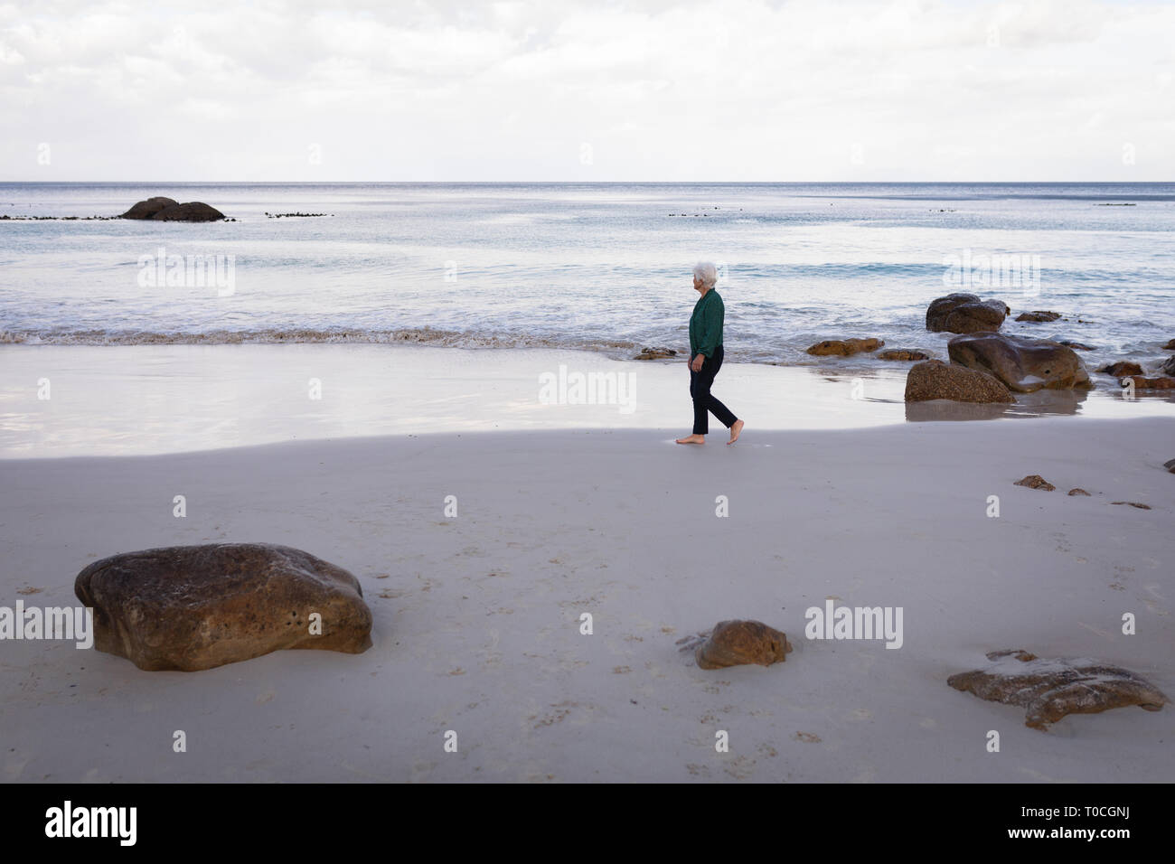 Senior woman walking beach hi-res stock photography and images - Alamy