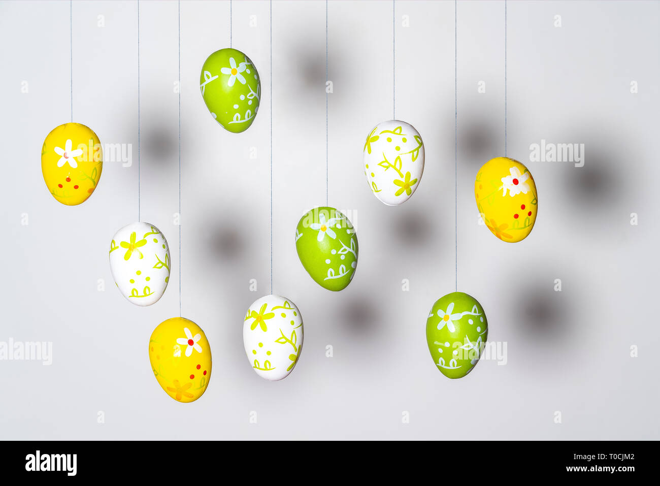 some colorful and decorated Easter eggs hanging by a thread Stock Photo