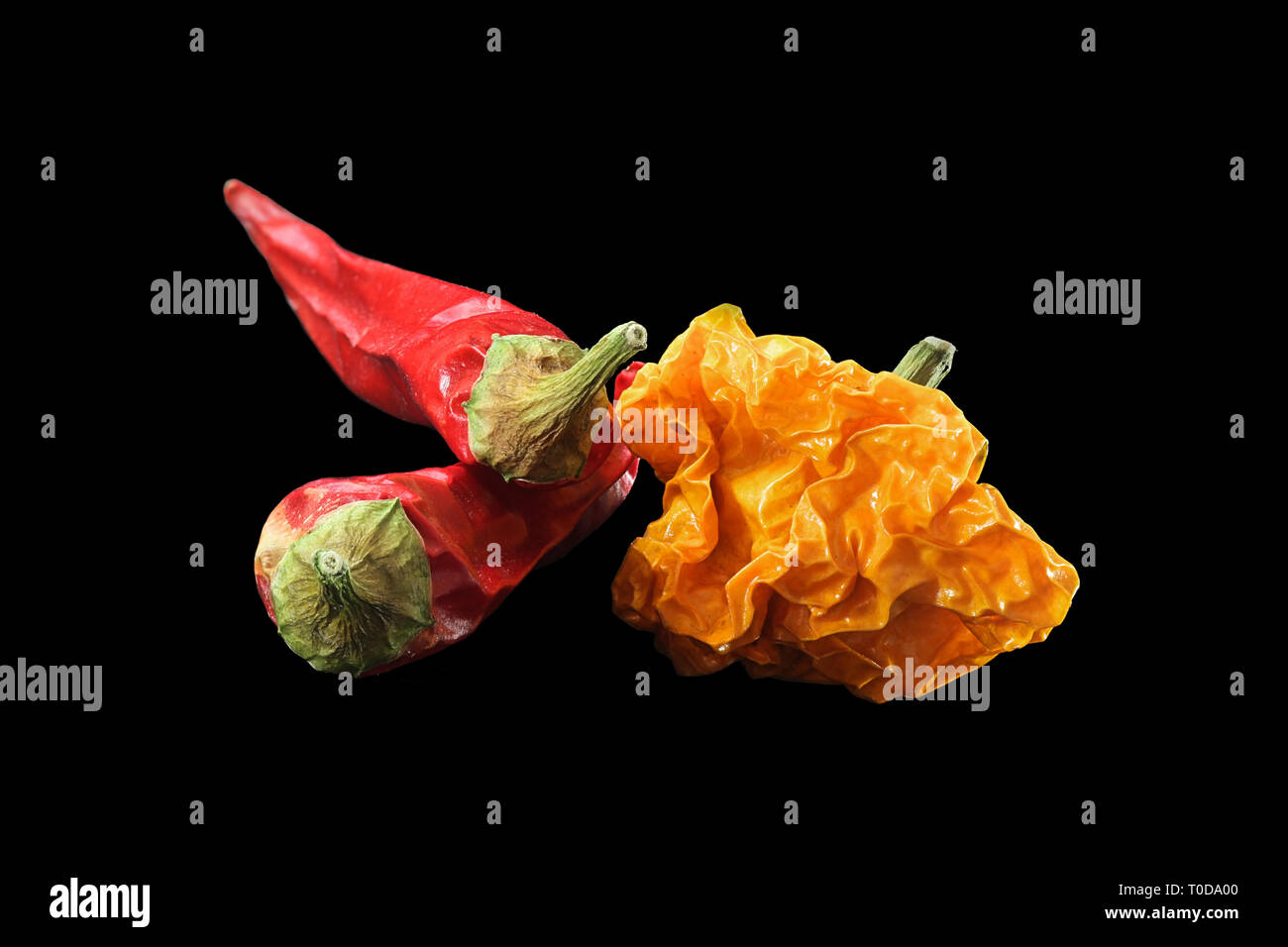 Red chili peppers and yellow habanero on black background Stock Photo