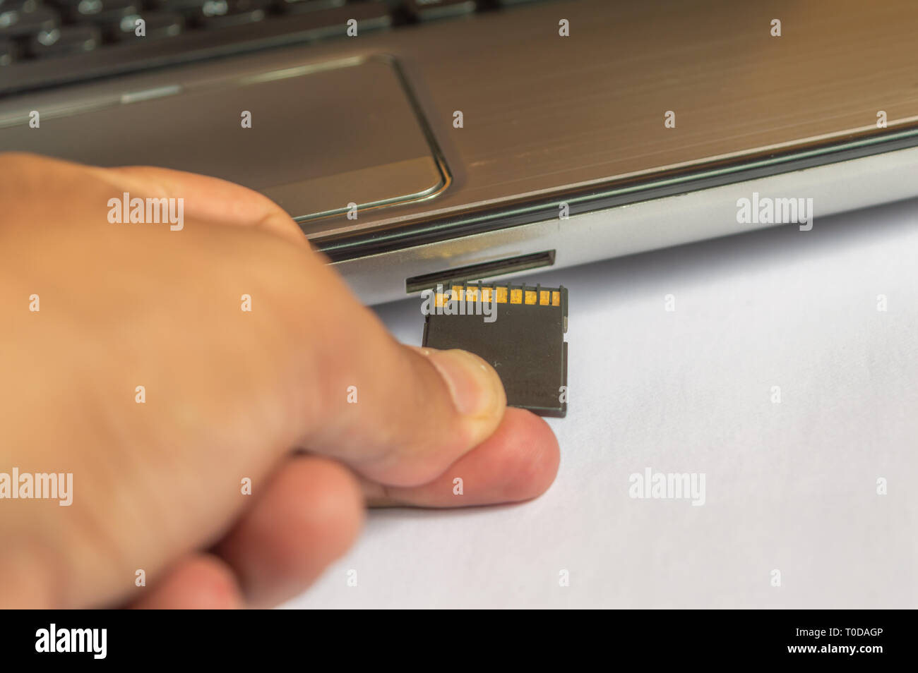 Inserting memory card flash drive into a computer laptop Stock Photo