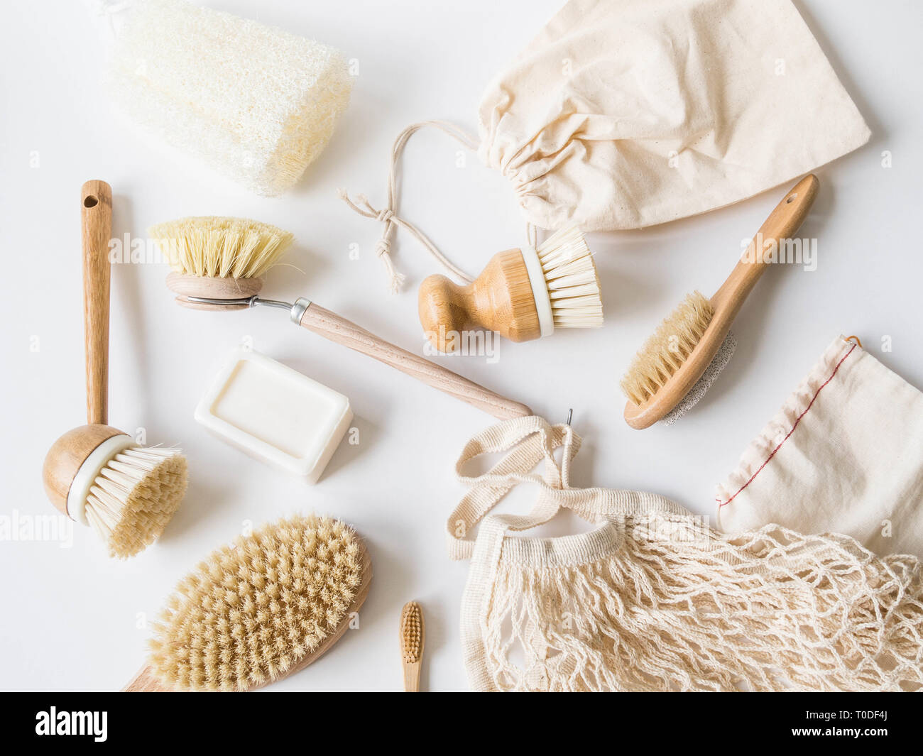 Dish washing brushes, bamboo toothbrushes, reusable bags on white background. Sustainable lifestyle zero waste concept. Clean without waste. Stock Photo