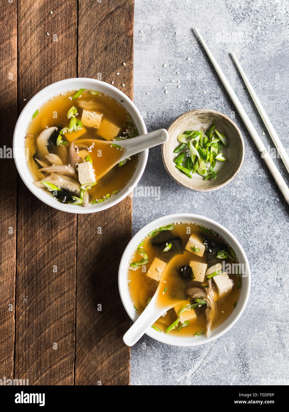 Japanese miso soup with oyster mushrooms in a white bowls with a spoon