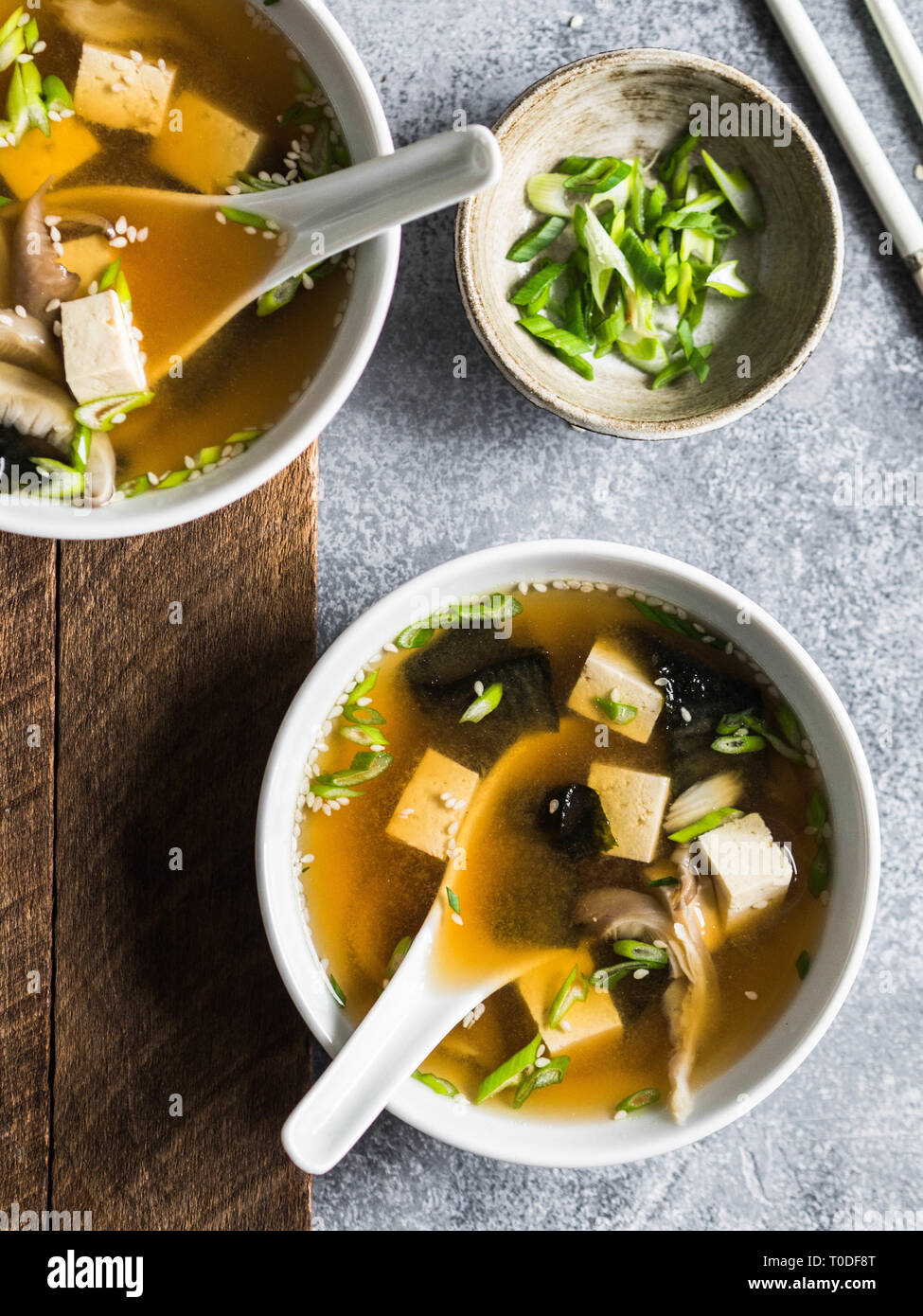 Japanese miso soup with oyster mushrooms in a white bowls with a spoon