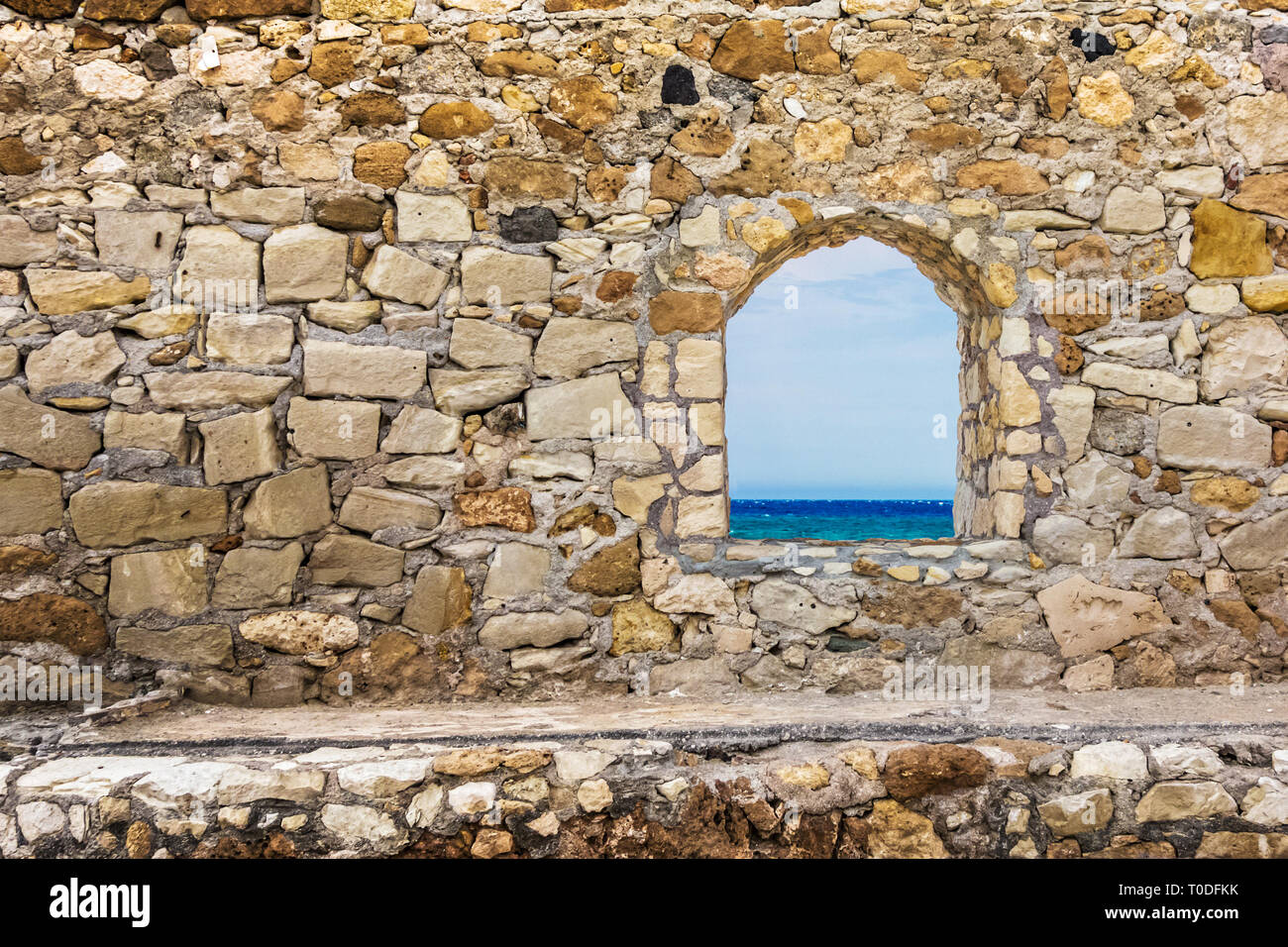 Stone ancient wall with a window. Sea view Stock Photo - Alamy