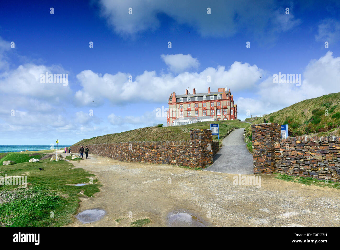 People walking along the coastal path near the Headland Hotel in Newquay in Cornwall. Stock Photo