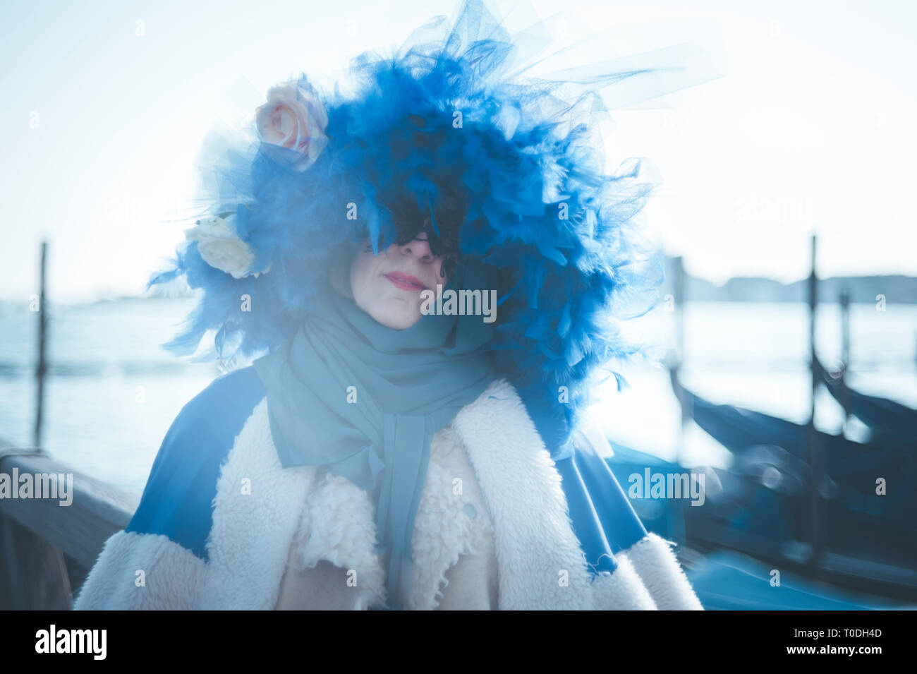 Masked woman with a blue feathers hat during the Venice carnival Stock Photo