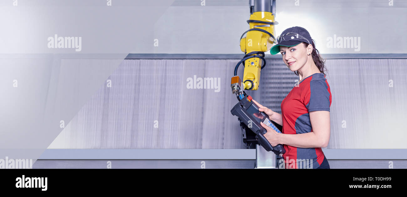 A young female technician while machine constructing in a manufacturing plant Stock Photo