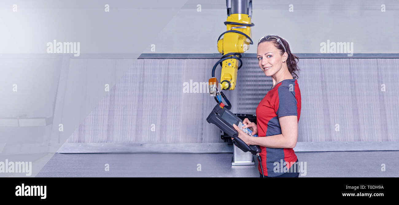 A young female technician while machine constructing in a manufacturing plant Stock Photo