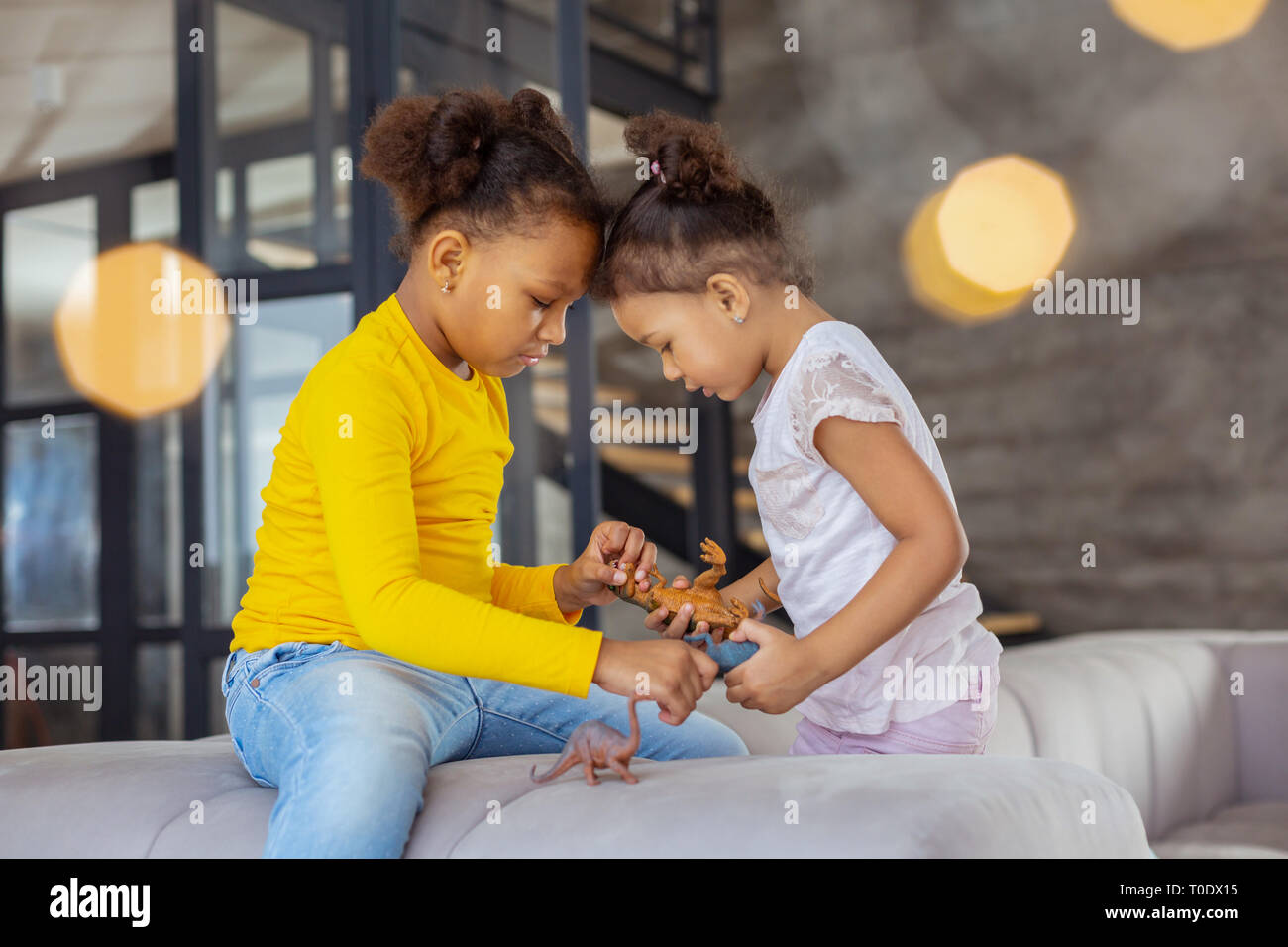 Two sisters looking at their favorite dinosaurs Stock Photo