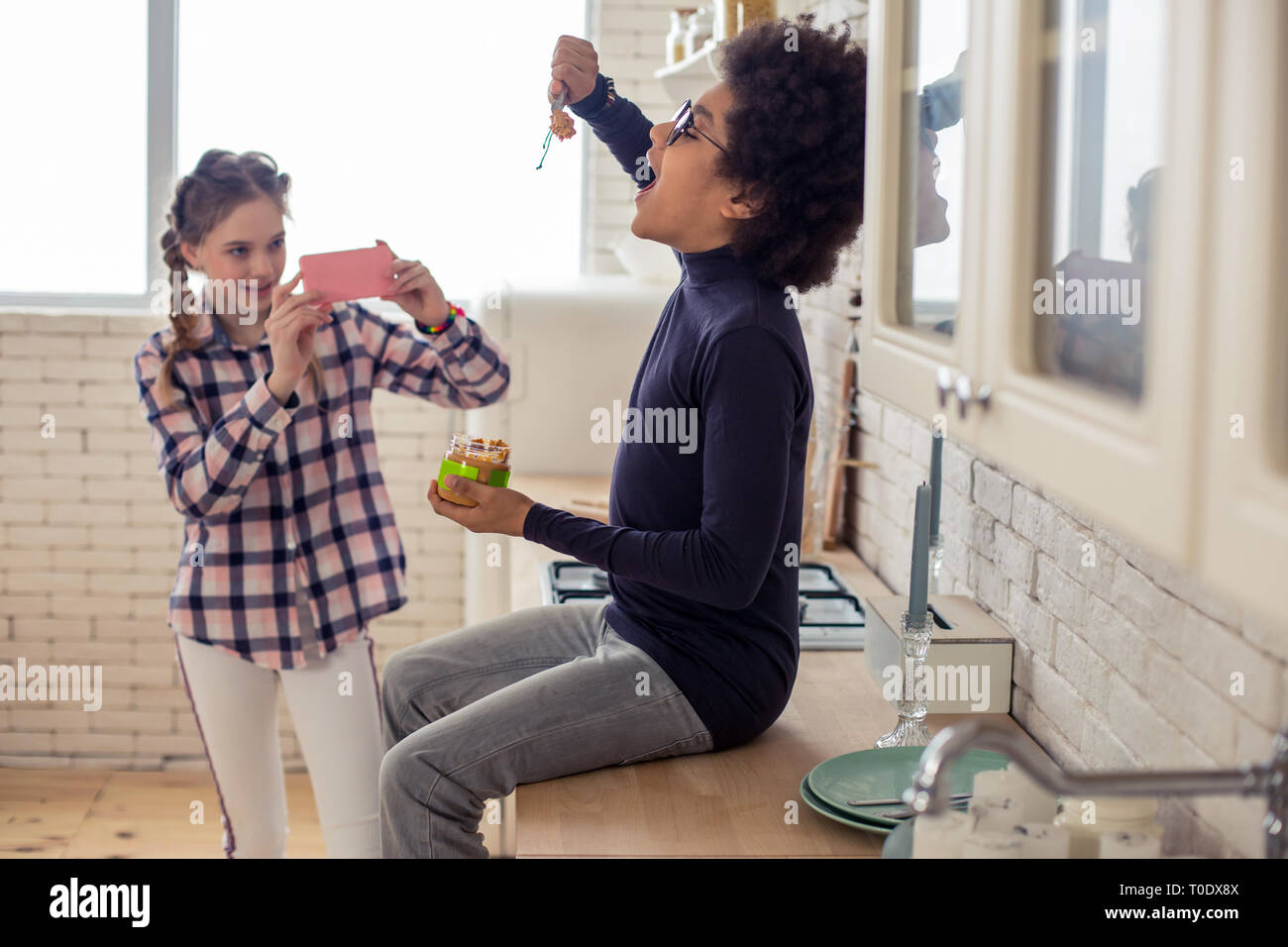 Cute longhaired kid using her telephone during game Stock Photo