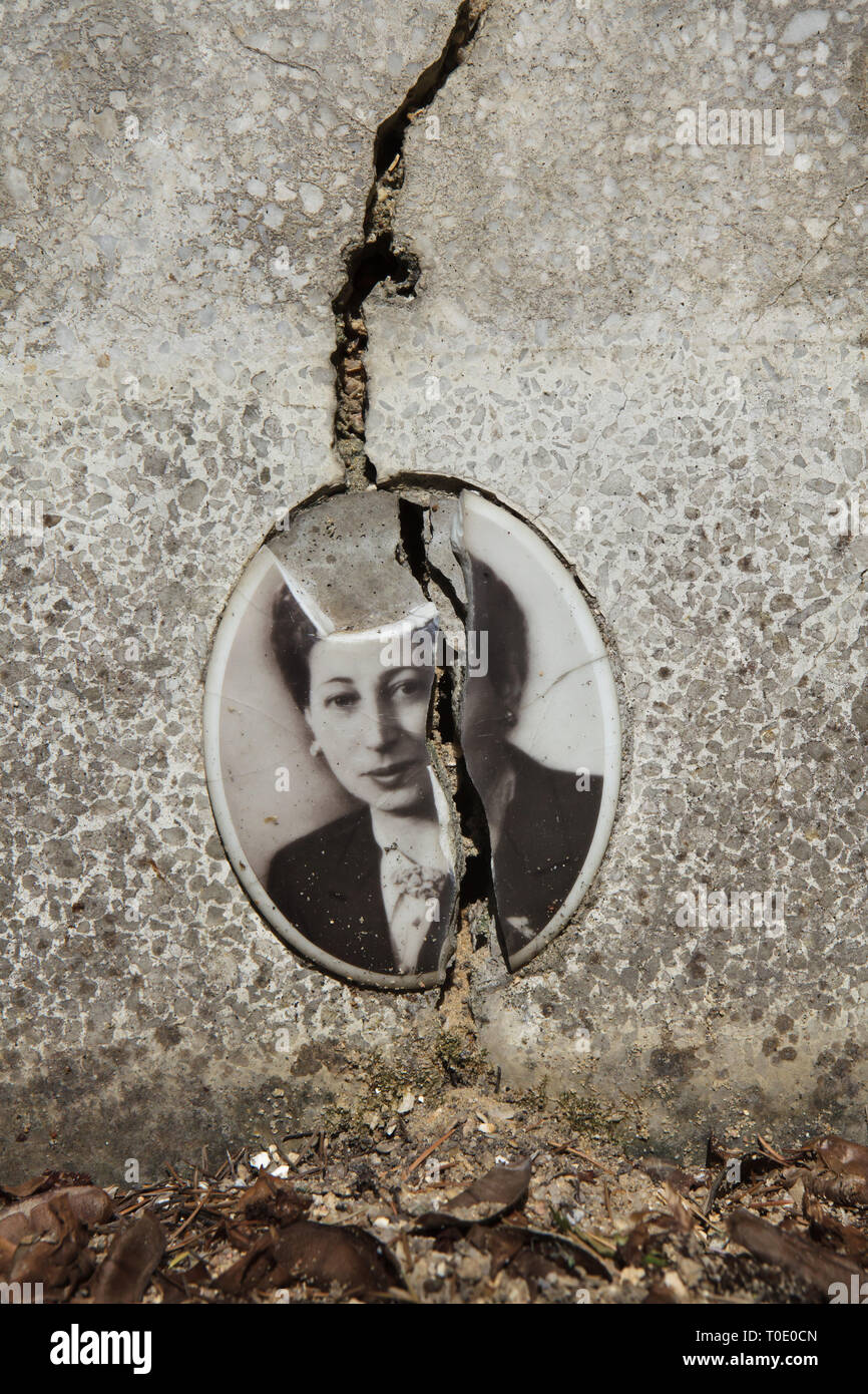Broken photograph of Russian emigrant Lidia Weissmann on her tombstone at the Russian Cemetery in Sainte-Geneviève-des-Bois (Cimetière russe de Sainte-Geneviève-des-Bois) near Paris, France. Lidia Weissmann was born on 27 December 1905, left Russia at age about 15, spent about 40 years in exile and died at age 55 on 11 April 1961. Stock Photo
