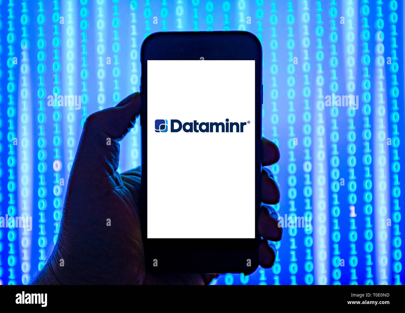 Person holding smart phone with Dataminr breaking news app logo displayed on the screen. Stock Photo