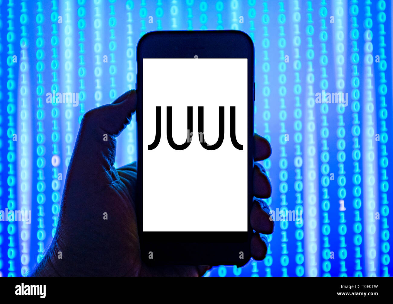 Person holding smart phone with JUUL e-cigarette company  logo displayed on the screen. Stock Photo