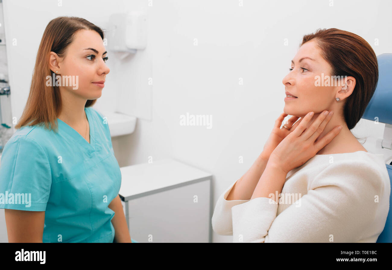 Female patient complain of throat pain to her otolaryngologist Stock Photo