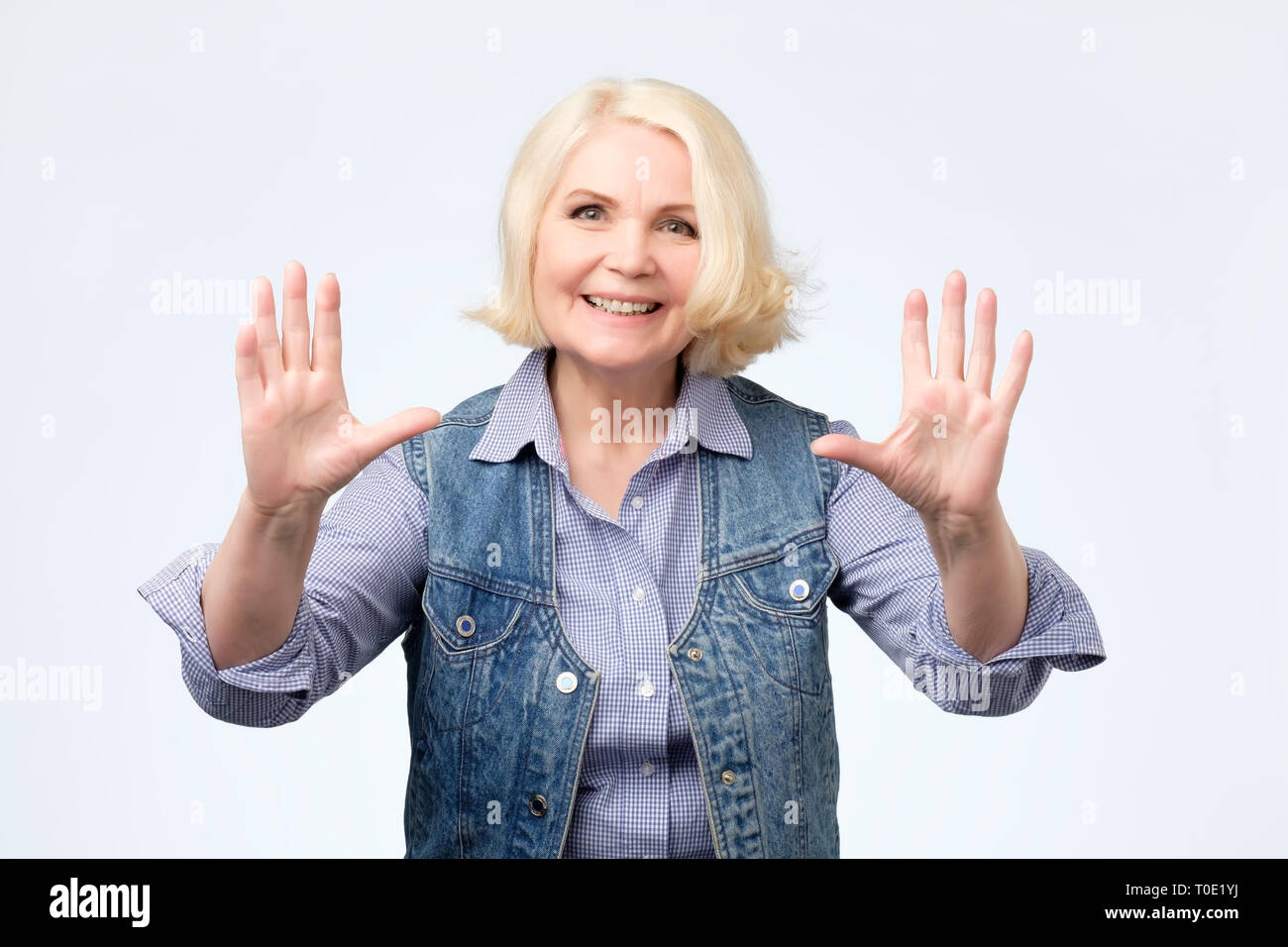 Happy senior blonde woman showing ten fingers Stock Photo - Alamy