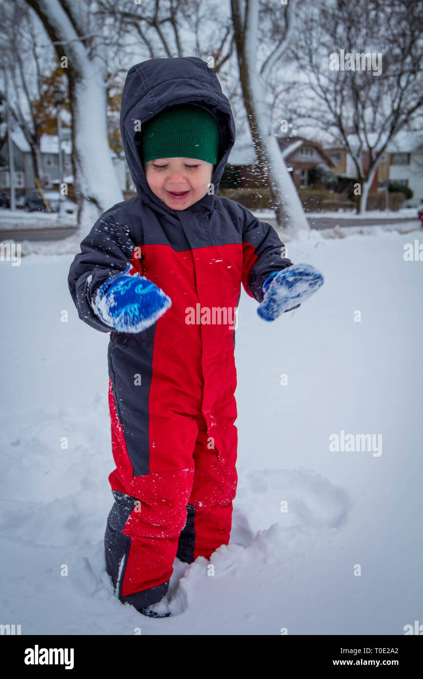 Toddler in snow suit enjoying the first snowy day. Stock Photo