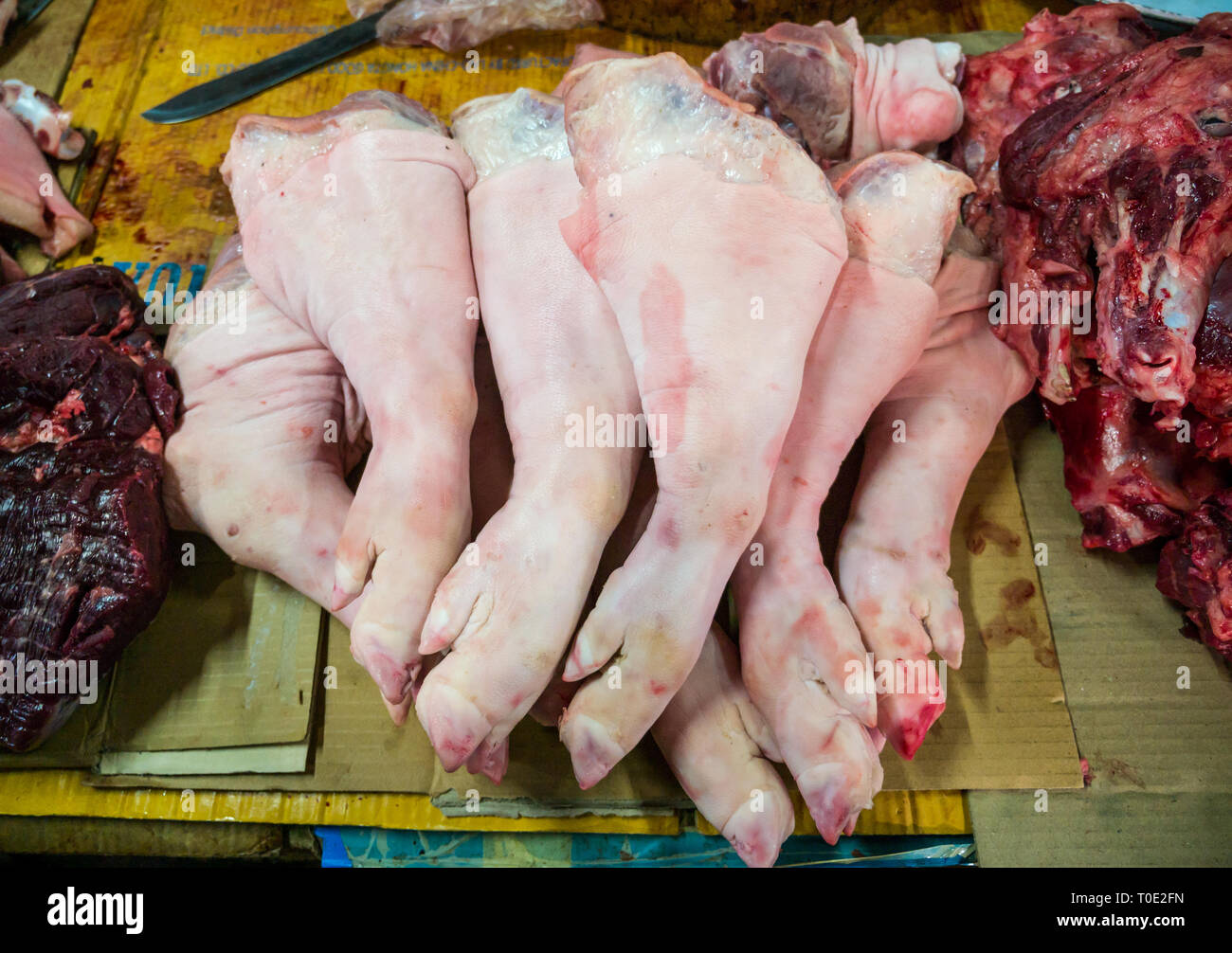 Pigs legs and trotters for sale at meat market stall, Phosy day market, Luang Prabang, Laos, SE Asia Stock Photo