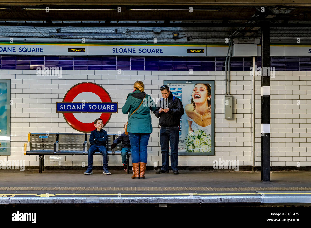 A family waiting on the platform at Sloane Square underground station , London , UK Stock Photo