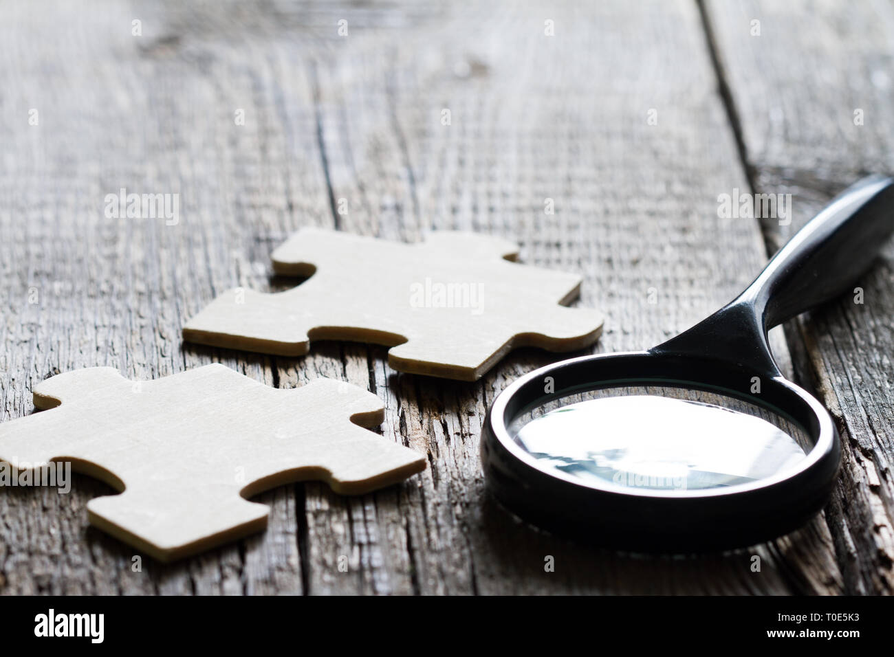 Looking for an employee partner in business concept with puzzle and magnifier Stock Photo
