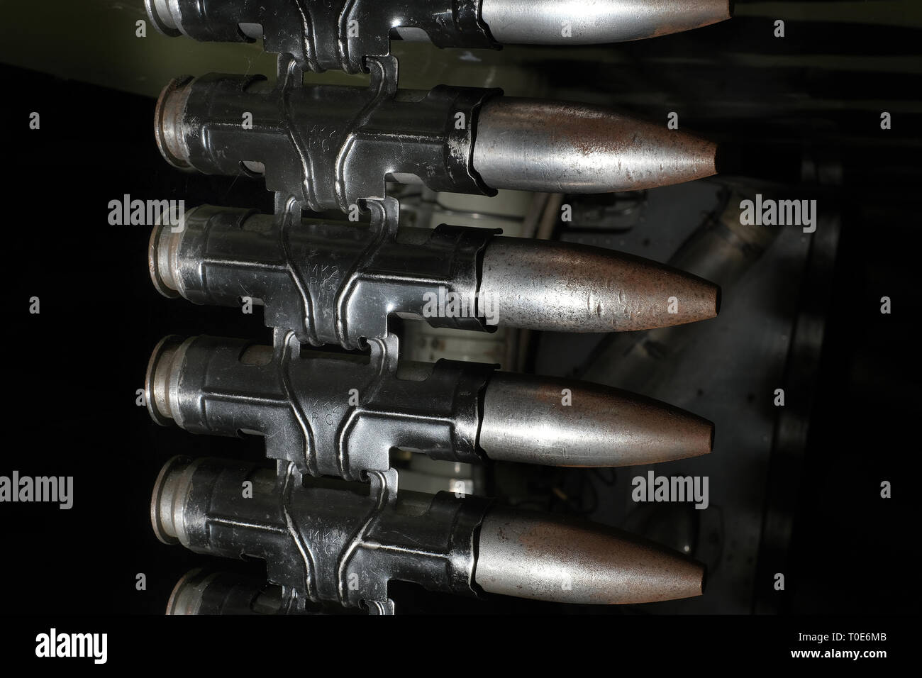 30 mm cannon shells in link ready to load into fast jet fighter aircraft weapon system. Stock Photo