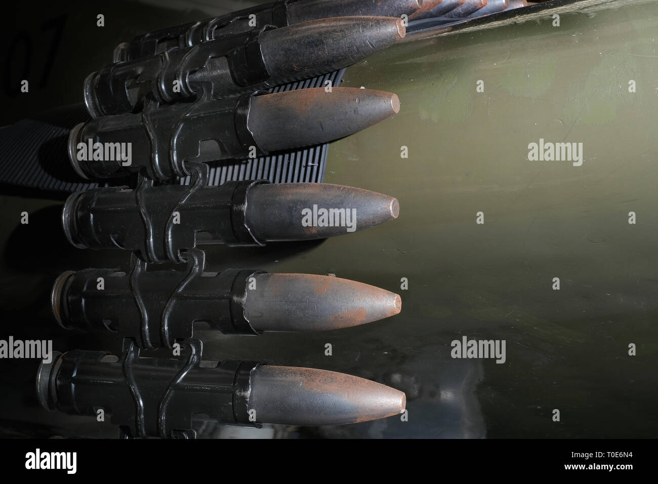 30 mm cannon shells in link ready to load into fast jet fighter aircraft weapon system. Stock Photo
