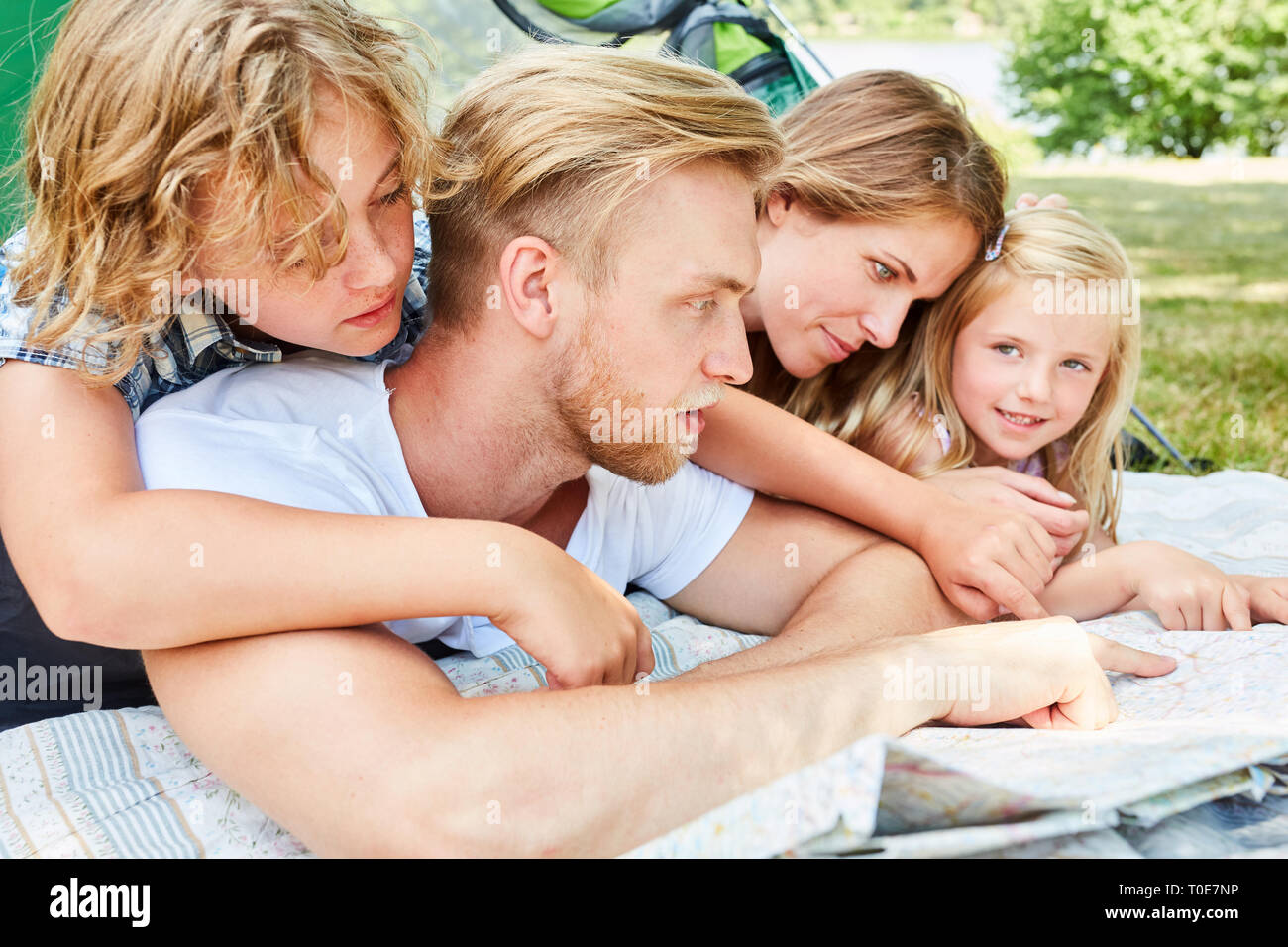 Family camping with two kids is studying map and planning a hike Stock Photo