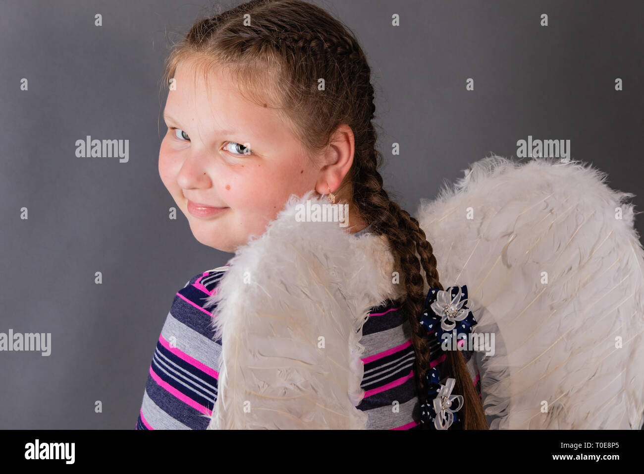 Strong stout smiling angel girl with wings. Stock Photo
