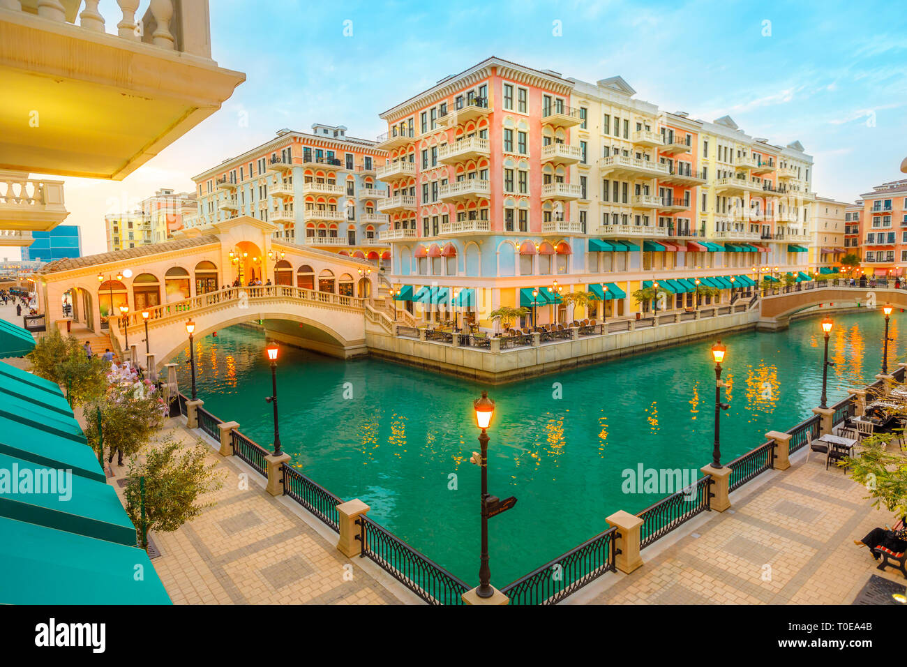 Aerial view of two Venetian bridges on canals of picturesque and luxurious district of Doha illuminated at blue hour. Scenic Venice at Qanat Quartier Stock Photo