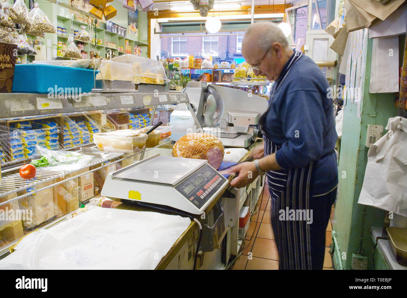Traditional Italian deli Lina Stores. A shop keeper cutting ham behind