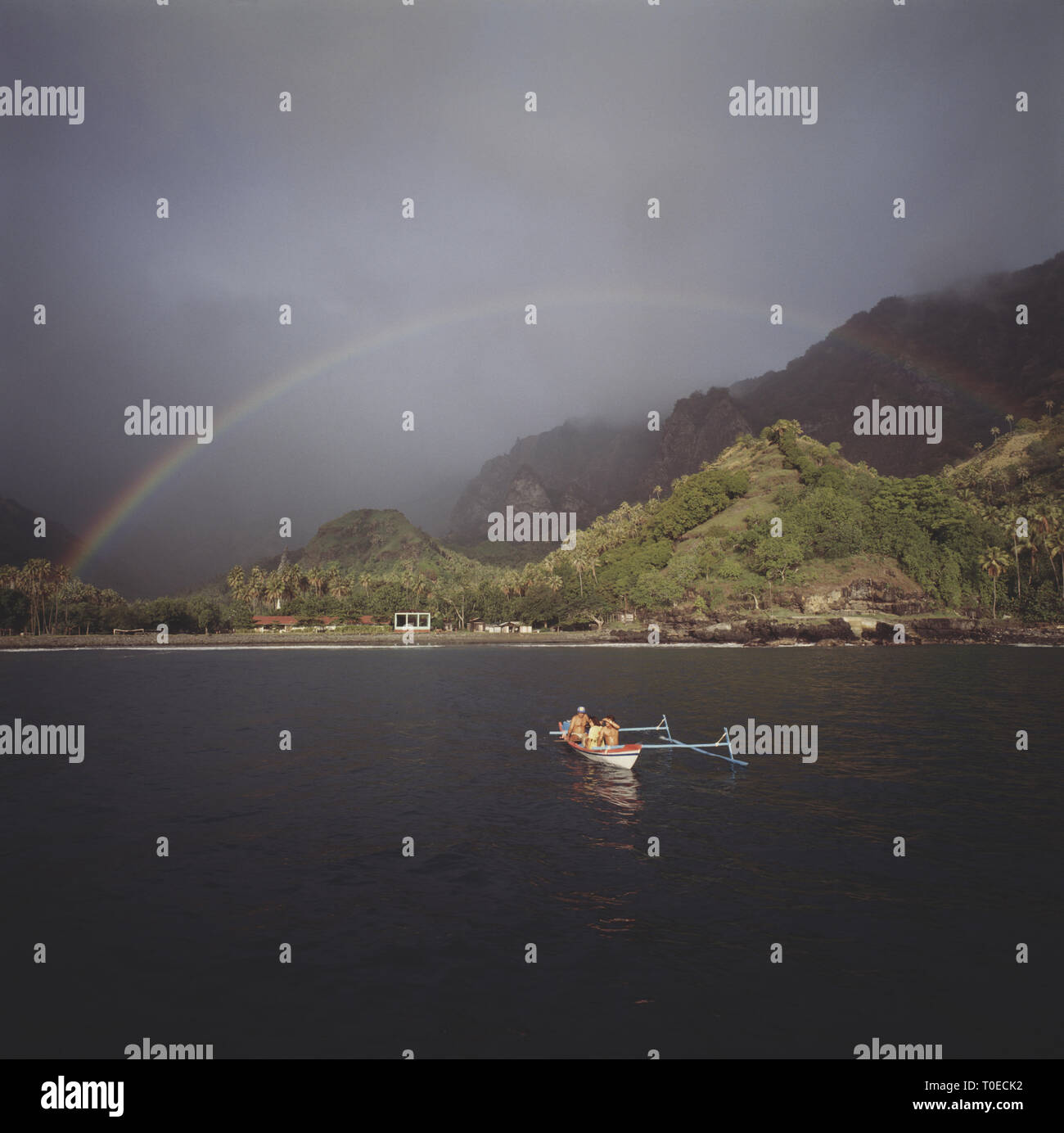 French Polynesia. Marquesas Islands. View of coast with outrigger canoe. Stock Photo