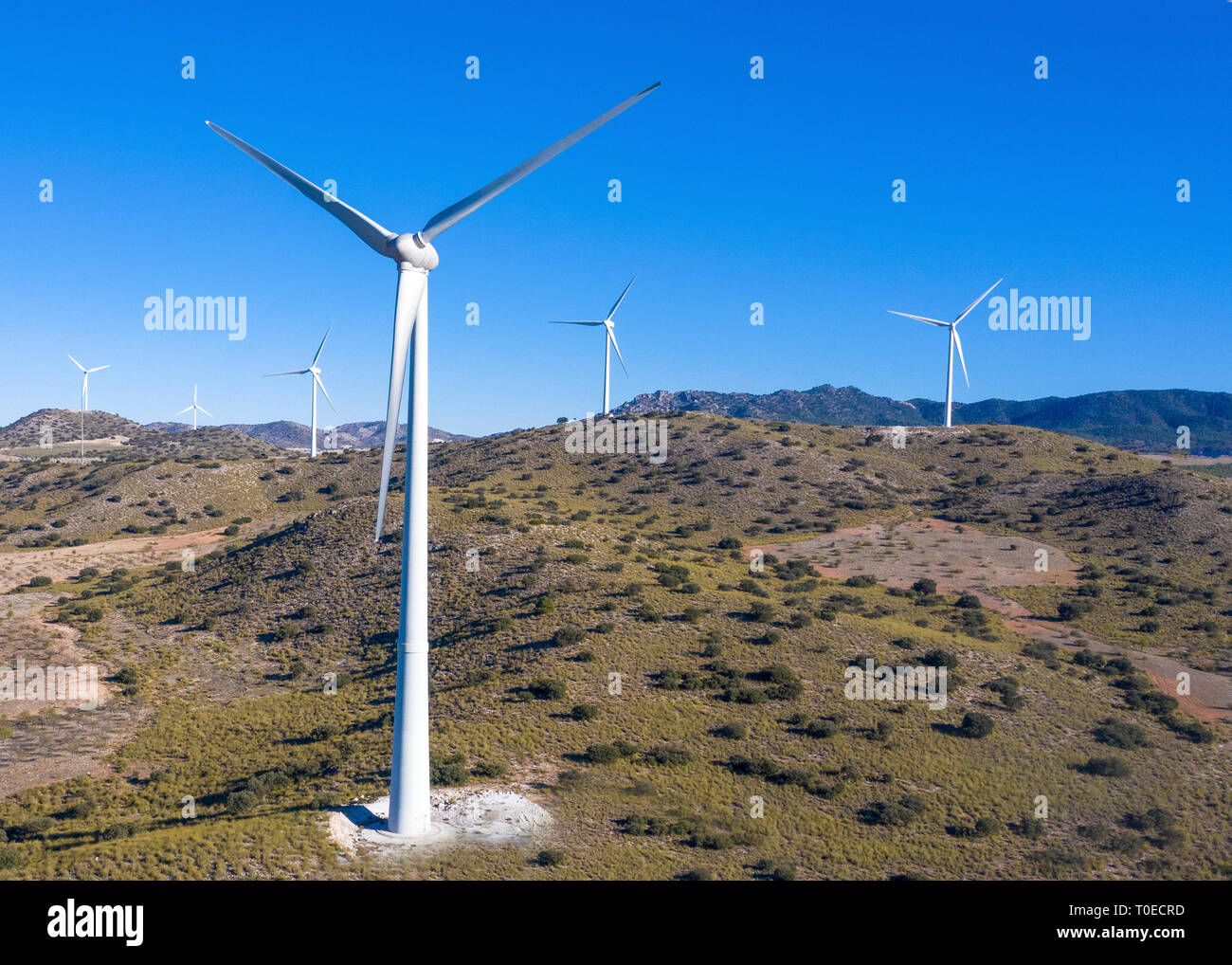 close up and high short of group of wind  turbine showing hills a blue sky background  for copy space shot from above Stock Photo