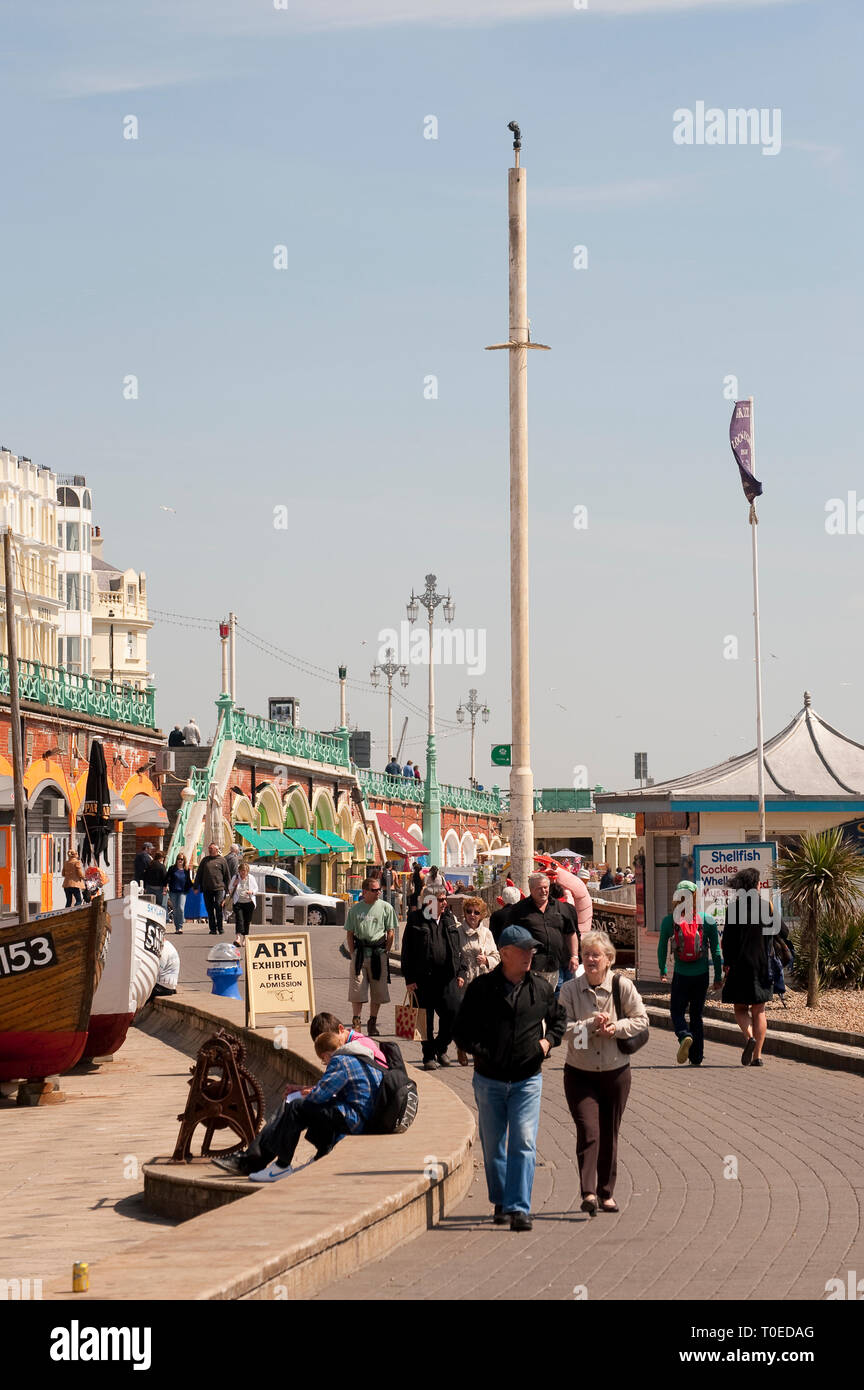 People walking along the promenade outside the fishing museum in the seaside town of Brighton, Sussex. Stock Photo