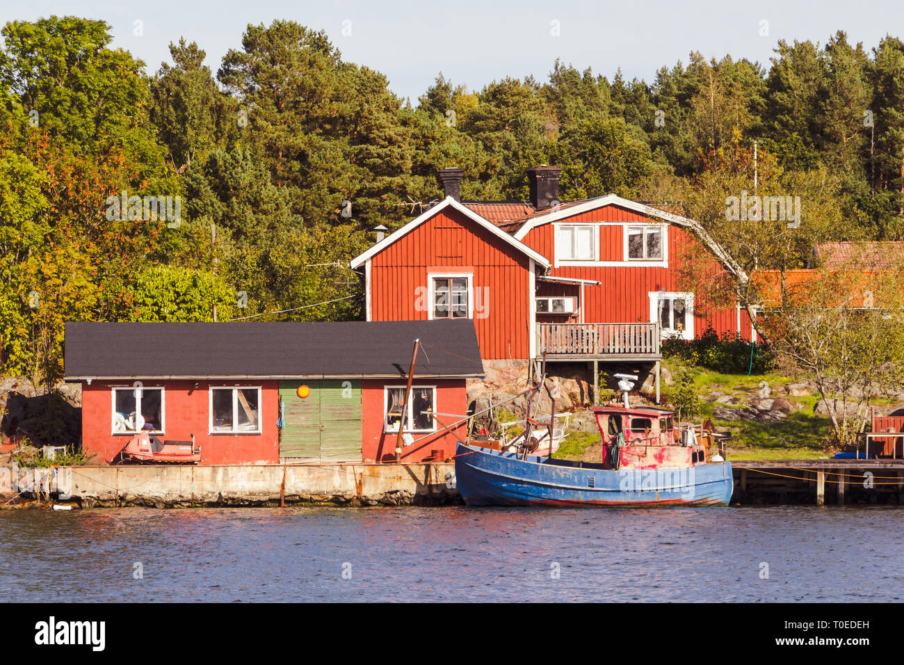 Red cottages and fishing boat in south Sweden Stock Photo